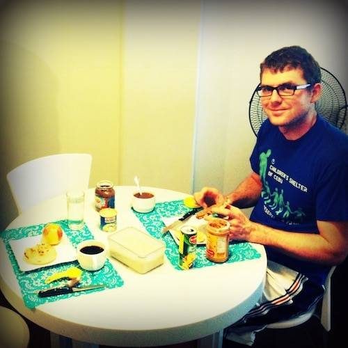 Man sitting at a small table eating.