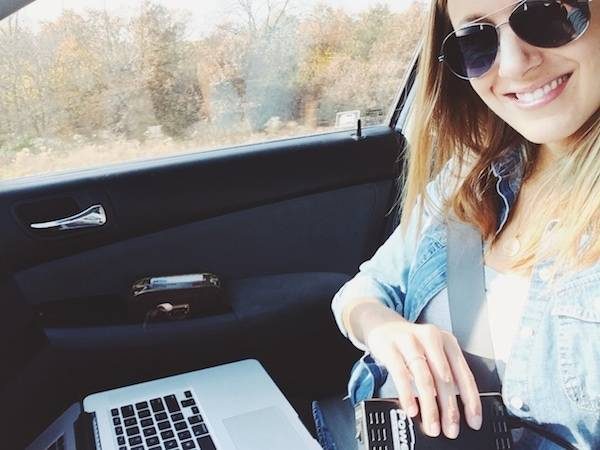 Woman working on her computer in the car.