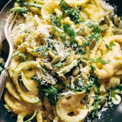 Creamy Corn Zoodles in a bowl with fork and spoon.