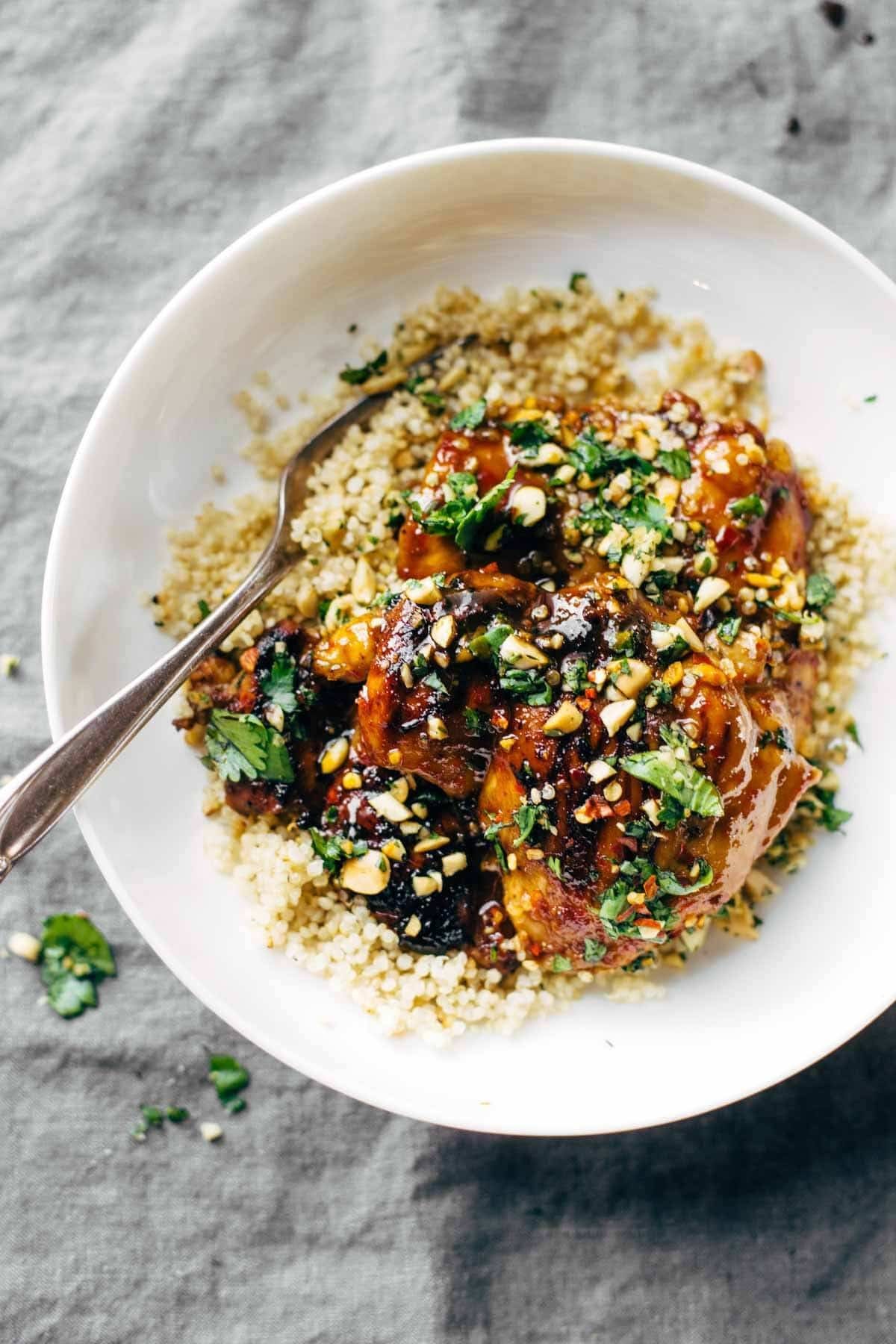 chicken with quinoa and cilantro in a bowl with a fork