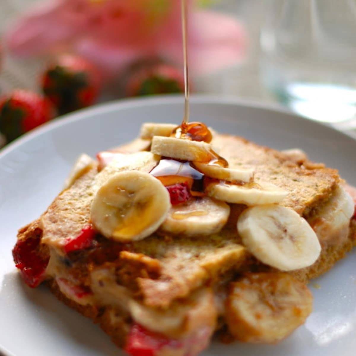 Stuffed French Toast with strawberries, bananas, and maple syrup drizzle.