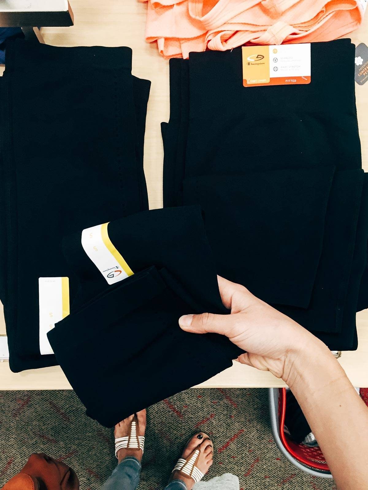 Hand holding black leggings.