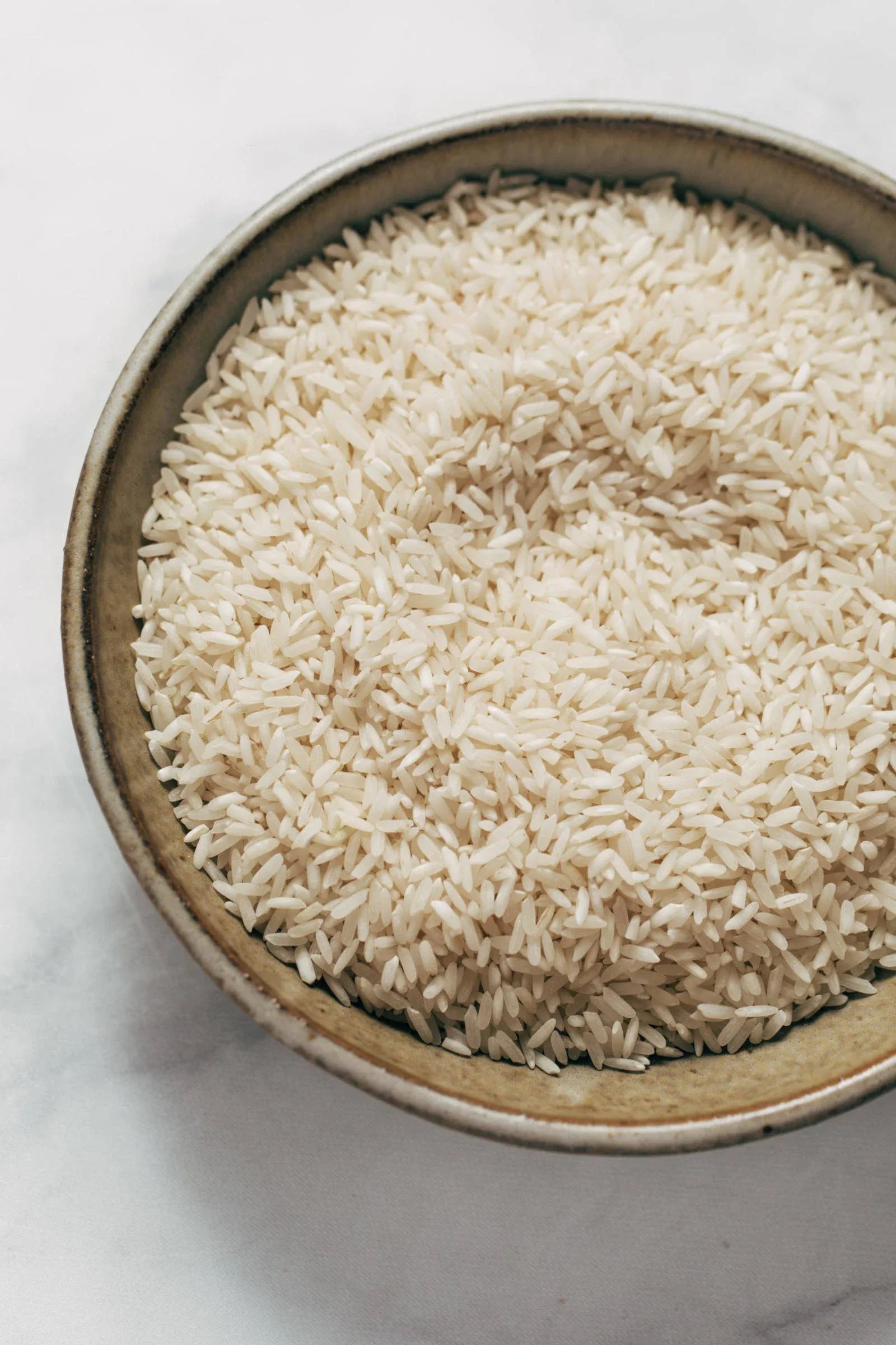 Raw white rice in a bowl.